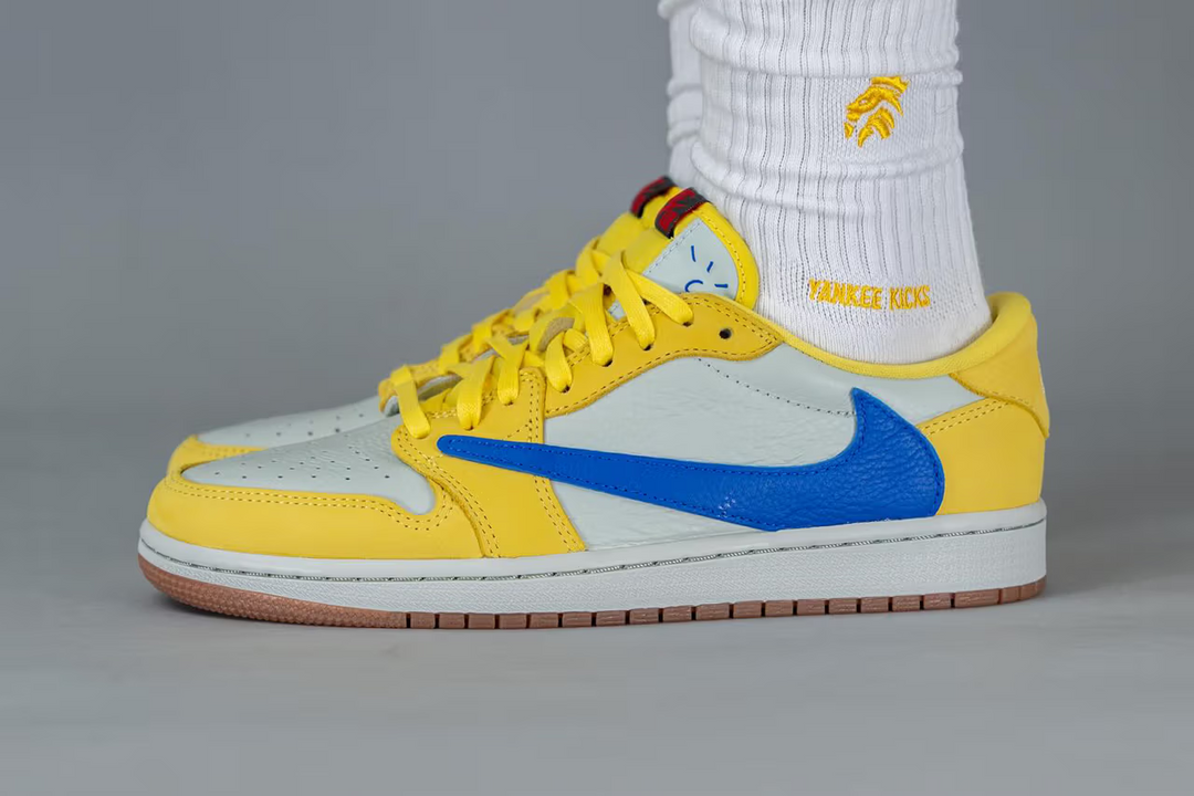 A glimpse of the Travis Scott x Air Jordan 1 Low OG "Canary" being worn.